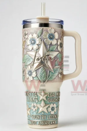 Loretta Lynn themed tumbler with floral patterns star emblem handle clear lid and straw displayed on a white background!