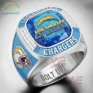 Close up of a Los Angeles Chargers themed ring with blue gemstone face lightning bolt logo Los Angeles Chargers text diamond style accents helmet side graphic and Bolt Up engraving inside the band