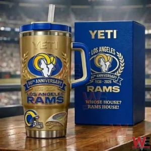 Los Angeles Rams 90th Anniversary 1936-2026 Gold Yeti Tumbler 3 Gold Los Angeles Rams 90th anniversary insulated tumbler with blue handle and straw displayed next to a matching blue gift box in front of a stadium background.
