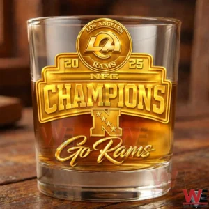 Clear whiskey glass with gold Los Angeles Rams NFC Champions logo filled with amber liquid displayed on a wooden table!