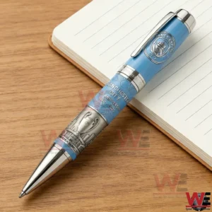 Commemorative blue pen with engraved silver details lying on a notebook!