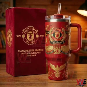 A red Manchester United themed insulated tumbler with gold decorative details stands next to a matching anniversary gift box on a wooden table!