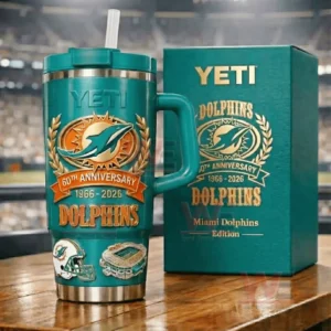 Teal YETI Dolphins 60th Anniversary tumbler next to a teal Dolphins themed gift box on a table with a blurred stadium behind!