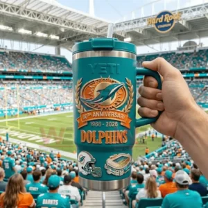 Hand holding a teal YETI Dolphins 60th Anniversary tumbler with a football stadium and field in the background!