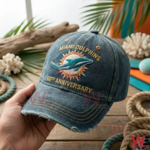 Hand holding Miami Dolphins anniversary cap with tropical decorations on a wooden table!