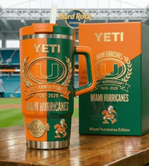 Orange and green Miami Hurricanes anniversary Yeti tumbler with straw and handle next to a matching orange and green box in front of a stadium backdrop.