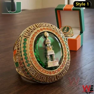 Gold and green championship ring with large gemstone detailed engraving and display box on a wooden table!