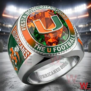 Championship ring with green and orange gemstone shown against a stadium background under bright lights!