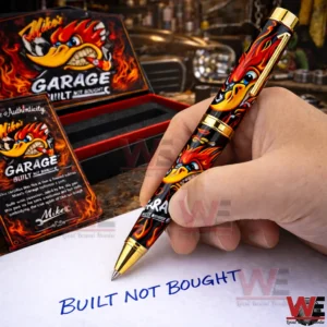 Mike Garage Built Not Bought Pen 5 Hand writing with a flame decorated black and gold pen while an open garage themed gift box and certificate sit in the background!