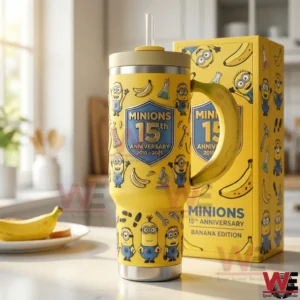 Yellow Minions themed tumbler with banana handle clear straw stainless steel base and anniversary graphics displayed on a kitchen counter beside a matching box!