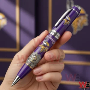 Hand holding a purple and silver Minnesota Vikings sixty fifth anniversary ballpoint pen with team logo anniversary text and stadium themed artwork against a purple Vikings themed background.