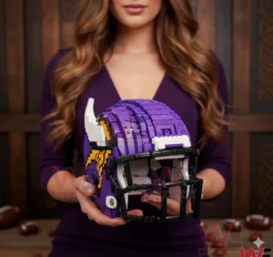 A person holding a purple Minnesota Vikings inspired football helmet constructed from interlocking building blocks with horn accents and a face mask visible from the front angle!