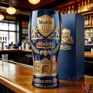 A commemorative Modelo beer glass marking one hundred years of brewing tradition standing on a bar counter with a decorative box in the background!