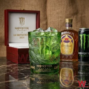 Green Monster Energy motocross commemorative glass with ice placed on a glossy surface with branded packaging and bottles in the background!