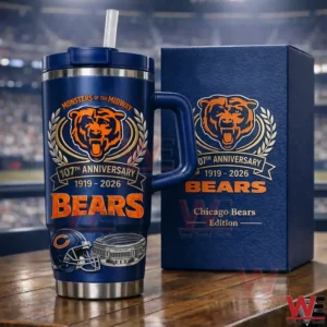 Dark blue Chicago Bears anniversary insulated tumbler with handle and straw beside a matching edition box on a wooden table with a blurred stadium background!