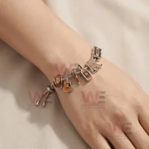 Adjustable charm bracelet on a wrist with cowboy hat guitar microphone whiskey bottle cowboy boots and Wallen name charms in silver and warm brown tones.