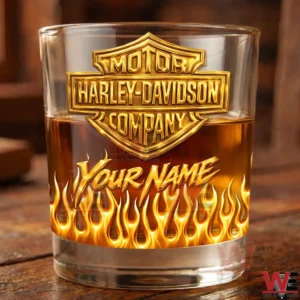 Motor Harley Davidson Company Custom Gold Glass 5 Close up of a personalized whiskey glass with gold Harley Davidson Company logo flame artwork and amber drink on a wooden table!