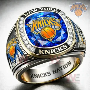 Close up of a New York Knicks themed ring with blue gemstone face New York Knicks logo diamond style border New York Knicks lettering skyline side graphics and Knicks Nation engraving inside the band