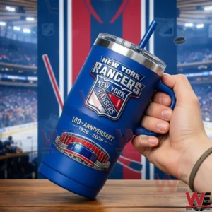 Hand holding a blue New York Rangers insulated tumbler with anniversary design against a hockey arena background!