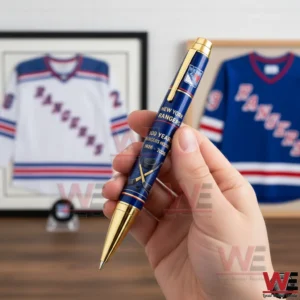 New York Rangers 100th Anniversary Limited Edition Pen 3 Hand holding a New York Rangers centennial pen with navy barrel gold trim team shield logo and hockey themed design in front of framed jerseys.