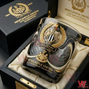 A Newcastle United anniversary commemorative glass placed inside a presentation box with visible crest gold accents and anniversary celebration design!