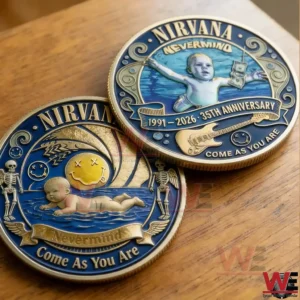 Two Nirvana Nevermind themed collectible coins on a wooden table showing detailed blue and gold artwork with anniversary text and iconic album inspired designs.