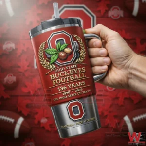 Hand holding a red Ohio State Buckeyes Football insulated tumbler with handle straw 136 Years text and 1890 2026 details on a red sports themed background!
