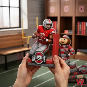 Ohio State Buckeyes 2026 Anniversary Bookends 3 A person holding an Ohio State Buckeyes bookend with a football player figure and Ohio State logo inside a sports themed room with lockers and matching decor!