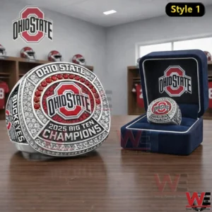 Silver Ohio State 2025 Big Ten Champions ring with Ohio State logo red and clear stones and a matching display box on a wooden table in a locker room setting!