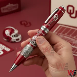 Oklahoma Sooners 130th Anniversary 1895-2025 Pen 3 Hand holding a red Oklahoma Sooners anniversary pen with detailed engravings!