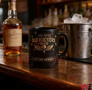 Black mug with a vintage badge style skull and wings design on a bar counter beside a bottle and an ice bucket!