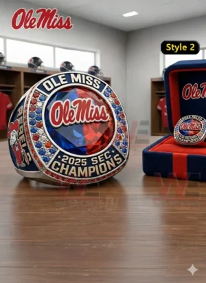 Ole Miss Rebels 2025 SEC Champions Custom Ring 3 Silver Ole Miss 2025 SEC Champions ring with red and blue gemstone style face Ole Miss logo red blue and clear stones and a matching display box on a wooden table in a locker room setting!