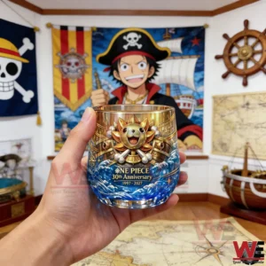 A One Piece anniversary whiskey glass with nautical artwork and bold commemorative details held in a themed room!