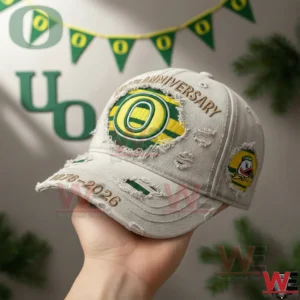 Hand holding white Oregon Ducks anniversary cap with team decorations in the background!