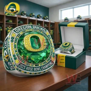 Oregon Ducks 2025 Rose Bowl Champions Ring 3 Oregon Ducks 2025 Rose Bowl Champions ring with a green gemstone centerpiece and gold Oregon O logo displayed beside a matching presentation box in a locker room setting!