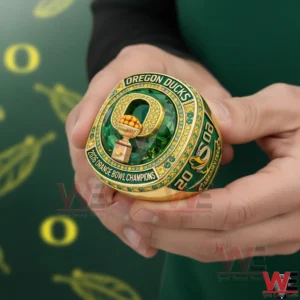 Oregon Ducks 2026 Orange Bowl Champions Custom Ring 5 Hands holding a green and gold Oregon Ducks championship ring with a trophy centerpiece and sparkling stone details!