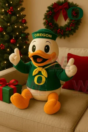 Oregon Ducks plush duck in a green outfit and Oregon cap sitting on a sofa with a Christmas tree wreath and gift box in a festive living room!