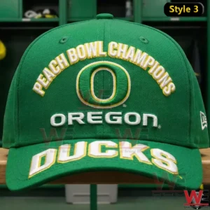 Front view of a green Oregon Ducks Peach Bowl Champions cap with arched text Oregon O logo and large Oregon Ducks lettering in a locker room!