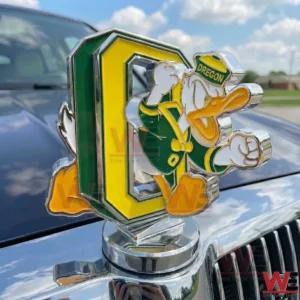 Oregon Ducks chrome hood ornament with green yellow O logo and Duck mascot positioned on a car hood with blue sky and clouds in the background!