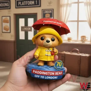 Hand holding Paddington Bear figure in a station themed background!