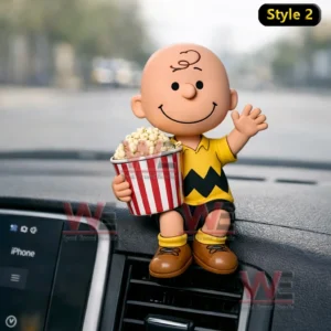 Smiling cartoon boy figurine holding a popcorn bucket and waving while sitting on a car dashboard.