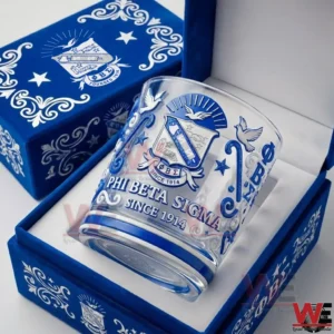 Clear whiskey glass with blue Phi Beta Sigma artwork placed inside a decorative blue gift box on a clean surface!