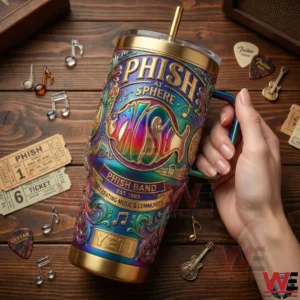 A close view of a hand holding a Phish at Sphere themed YETI tumbler with colorful patterns musical notes and concert memorabilia in the background!