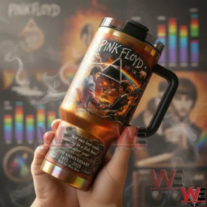 Pink Floyd Wish You Were Here 50th Anniversary Stanley Tumbler 5 Close up of a Pink Floyd prism and rainbow handled tumbler held in hand with anniversary text and a colorful music themed background!