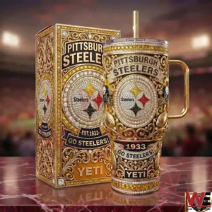 A Pittsburgh Steelers themed insulated tumbler with intricate patterns and classic team branding stands next to its matching box on a reflective surface in a professional stadium!