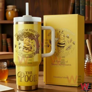 Yellow handled tumbler with straw and bear and bee illustration placed next to a themed box on a wooden surface!