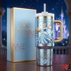 Cinderella anniversary insulated tumbler with gold handle and straw next to a matching gift box with a glowing castle night backdrop!