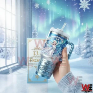 Hand holding a Frozen themed anniversary insulated tumbler with snowflake design and icy artwork in a winter background!
