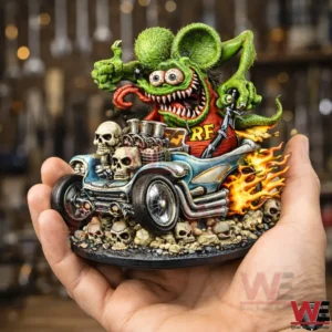 Hand holding a green Rat Fink style monster hot rod resin statue with skull base and flame effects in a workshop background.