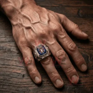 A hand wearing a large silver championship ring with a deep blue gemstone face Rush lettering a red star emblem and sparkling stone borders.